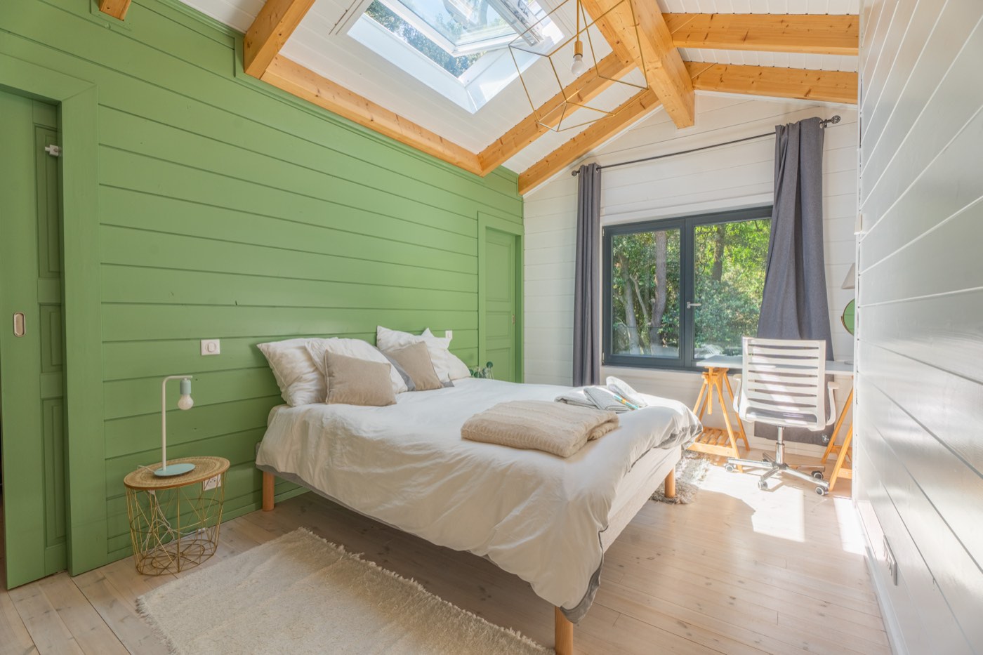 Chambre parentale à l'étage avec lit 160 cm, mur vert sapin, velux et bureau sous charpente